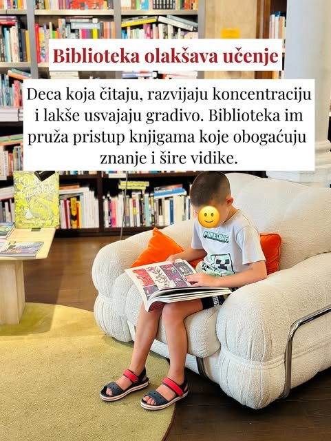 Dečak u majici sa Majnkraft motivom sedi u pufnastoj beloj fotelji i čita strip, uz narandžasti jastuk iza leđa.