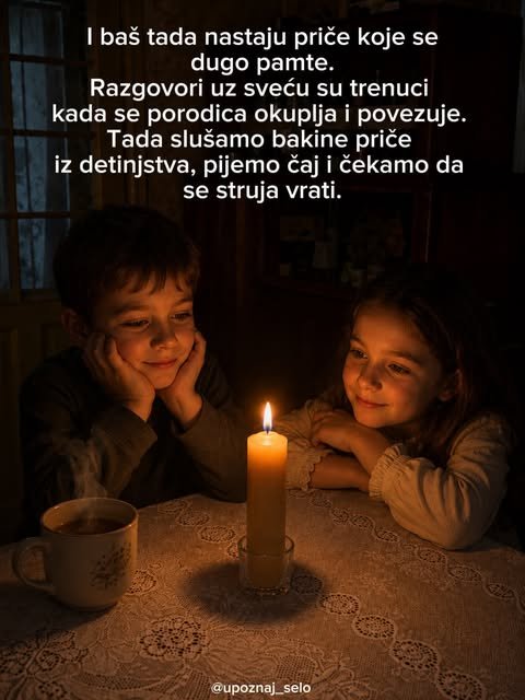 Dečak i devojčica osmehnuti sede za stolom i gledaju u plamen sveće, a pored njih para šolja čaja.