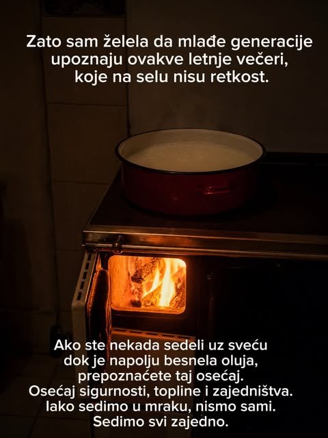 U mračnoj kuhinji gori vatra u drvenom šporetu, a na ringli stoji crveni lonac iz kog izlazi para.