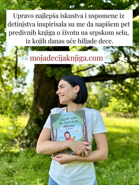Nasmejana autorka sa slikovnicom Jedan dan na seoskom imanju u rukama stoji ispred starog drveta.