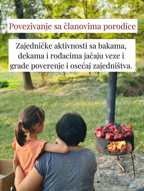 Devojčica se oslanja na baku dok na maloj peći u dvorištu peku crvene paprike.