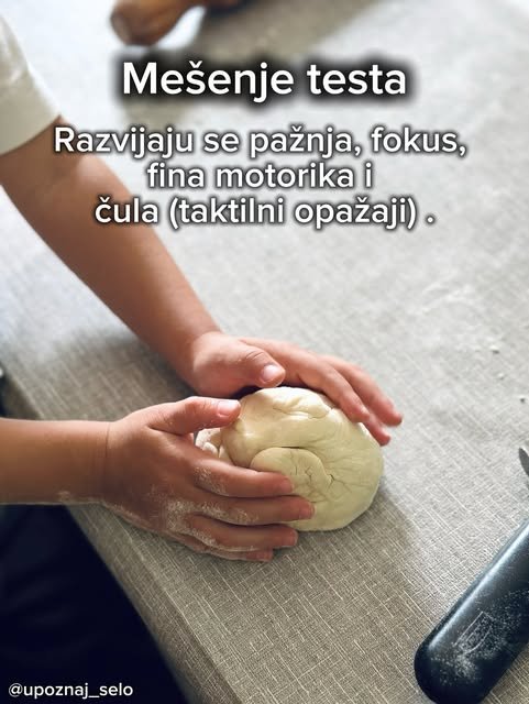 Dečje ruke oblikuju loptu od testa na brašnjavoj radnoj površini u kuhinji.