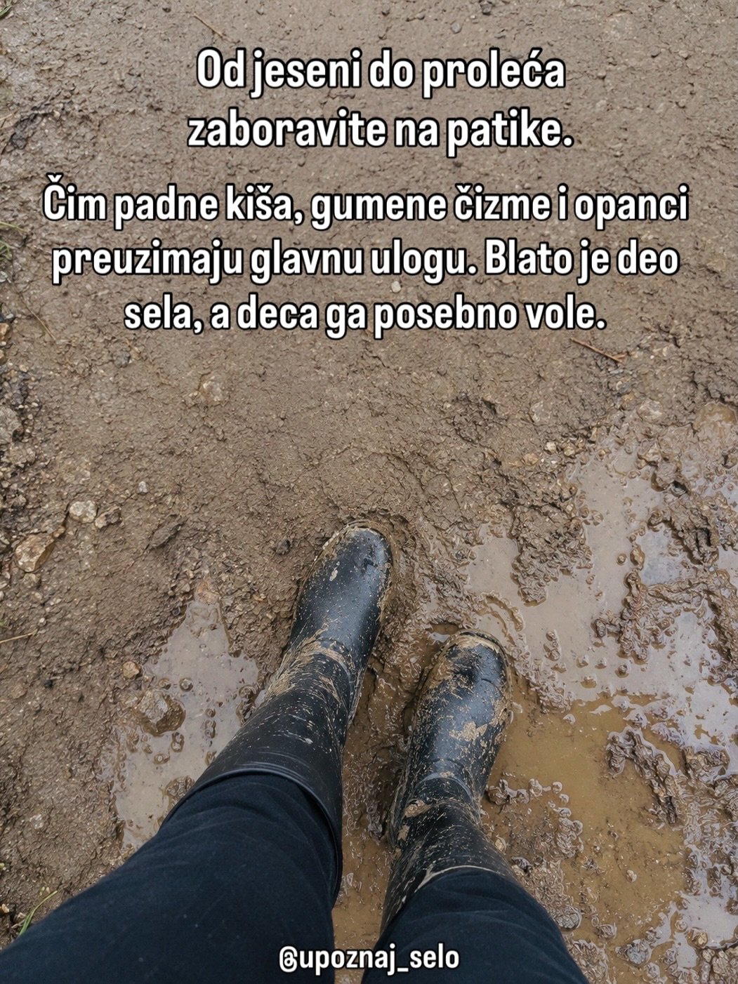 Noge u crnim gumenim čizmama stoje u blatnjavoj lokvi na seoskom putu.